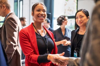 A businesswoman shaking hands at a networking event.